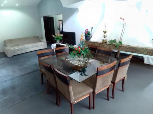 uma sala de jantar com uma mesa de vidro e cadeiras em Pousada Bom Jesus em Ponta Grossa