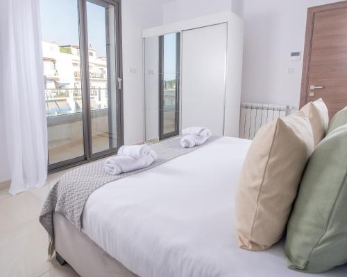 Un dormitorio con una cama blanca con toallas. en Appartement Luxueux à Kouba en Kouba