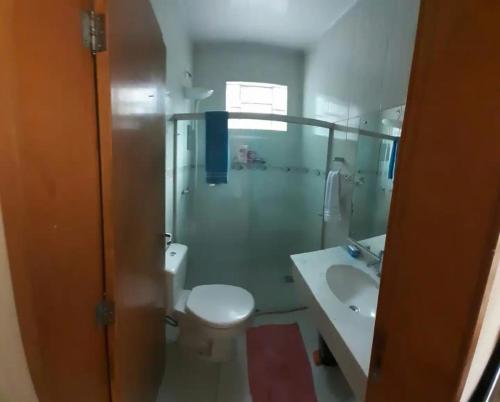 a bathroom with a shower and a toilet and a sink at Pousada Bom Jesus in Ponta Grossa