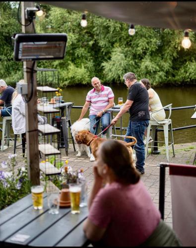 a group of people sitting at tables with a dog at The Cock and Magpie in Bewdley