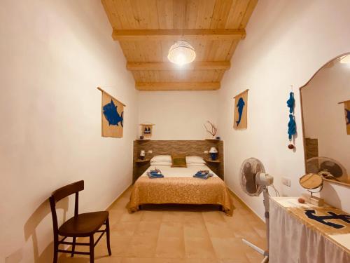 卡洛福泰的住宿－Guest House Calalunga Scogliera，一间卧室,卧室内配有一张床和一把椅子