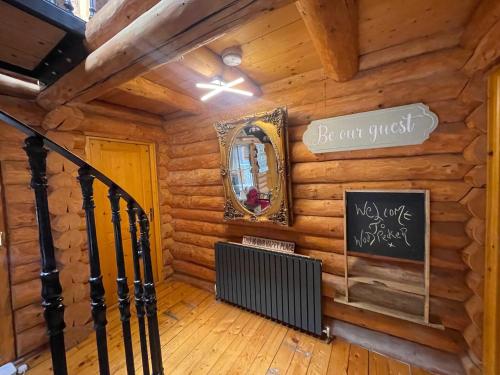 a room in a log cabin with a sign on the wall at Woodpecker Log Cabin with hot tub, pizza oven bbq entertainment area, lakeside with private fishing peg situated at Tattershall Lakes in Tattershall