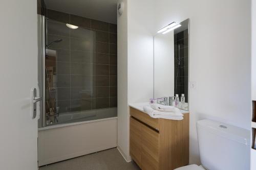 een badkamer met een douche, een toilet en een wastafel bij Résidence Néméa Le Domaine d'Uhaina in Urrugne
