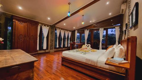 a bedroom with a bed in a room with windows at Avalon Ubud Castle & SPA in Ubud