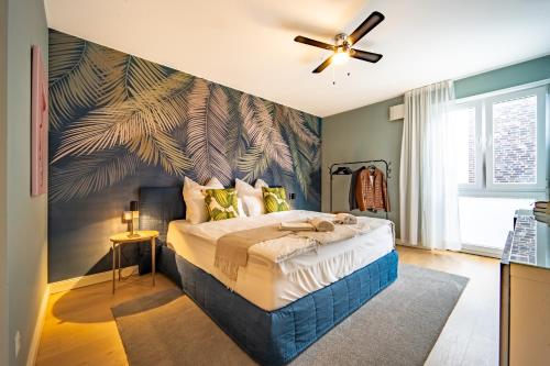 ein Schlafzimmer mit einem großen Bett mit einer grünen Wand in der Unterkunft LUXX APARTMENTS I Luxx Central I Design I Komfort in Bad Zwischenahn
