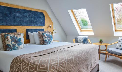 a bedroom with a large bed and two chairs at Fairlawns, Hotel And Spa in Walsall