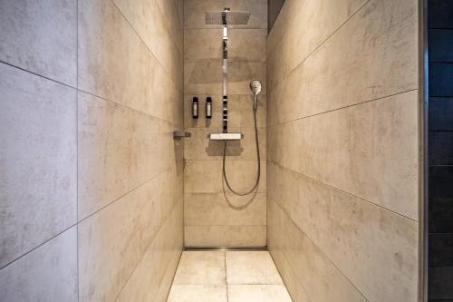 een badkamer met een douche met een douchekop bij LUXX APARTMENTS I Luxx Central I Design I Komfort in Bad Zwischenahn