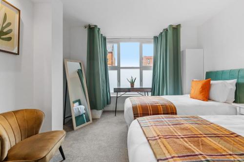 two beds in a hotel room with green curtains at Ground Floor Apartment with Courtyard in Loughborough