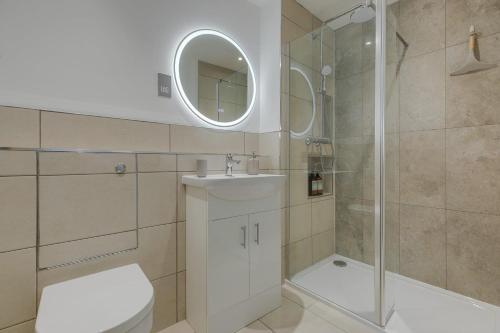 a bathroom with a shower and a toilet and a sink at Ground Floor Apartment with Courtyard in Loughborough