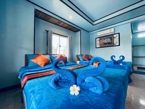 a bedroom with a bed with swans on it at Markhouse Bungalow Ko Kut in Ko Kood