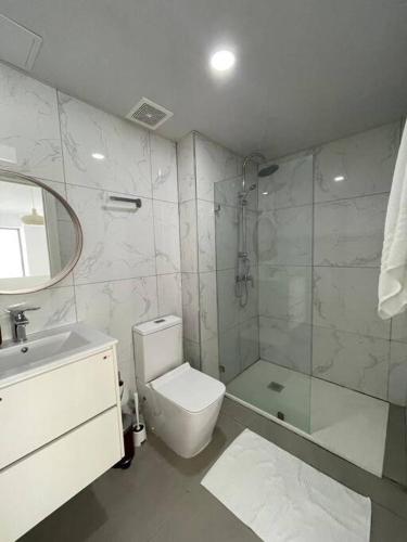 een badkamer met een douche, een toilet en een wastafel bij Agreable Duplex tout confort. in Santo Domingo