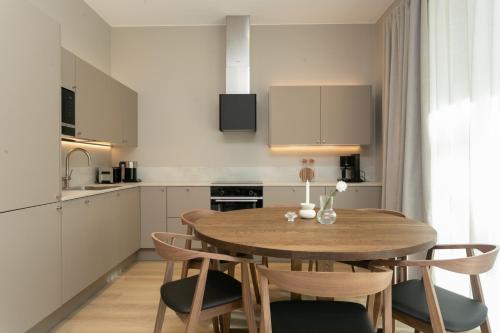 a kitchen with a wooden table and chairs at Arctic Circle Holiday homes II in Rovaniemi