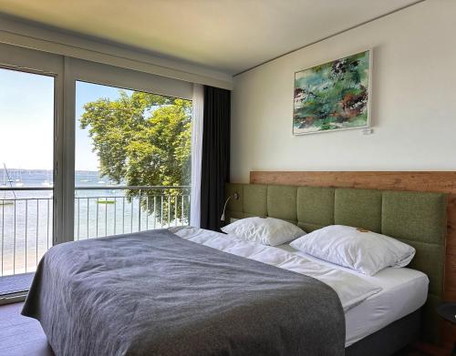 a bedroom with a large bed and a large window at Seespitz Gästehaus in Herrsching am Ammersee