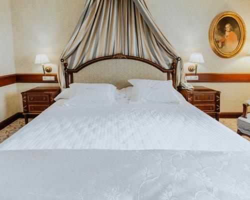 1 dormitorio con 1 cama blanca grande y 2 mesitas de noche en Hotel Cándido, en Segovia