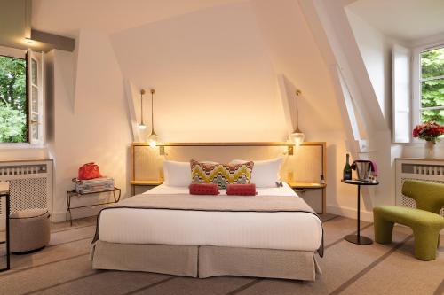 um quarto com uma cama grande e uma cadeira verde em Hôtel & Spa de La Bretesche em Missillac
