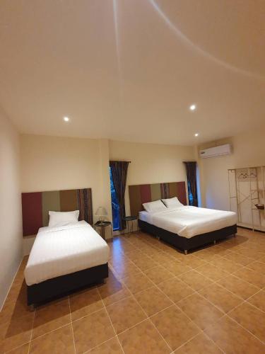 a bedroom with two beds and a tiled floor at กมุทมาศ สวรรคโลก in Ban Pa Muang (1)