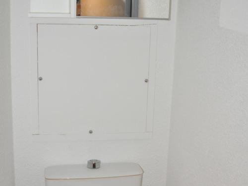 une salle de bain blanche avec toilettes et fenêtre dans l'établissement Studio cabine au pied des pistes, balcon, accueil animaux - FR-1-557A-20, à La Ferrière