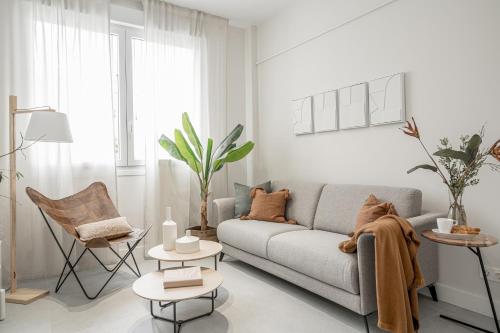 a white living room with a couch and chairs at Apartamentos Pamplona by Clabao in Pamplona