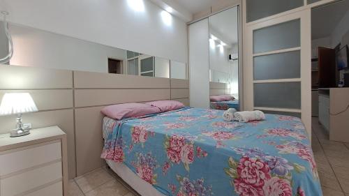 Dormitorio pequeño con cama con espejo en Apartamento de 1 quarto de frente a praia dos Ingleses, en Florianópolis