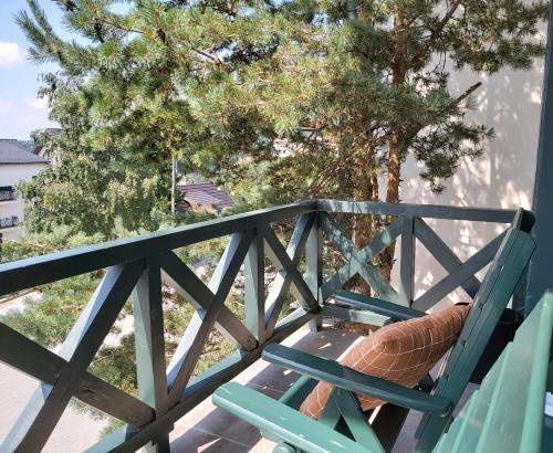 a green chair sitting on a balcony with a tree at Apartman Dragana Kopaonik in Kopaonik