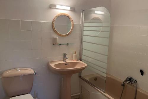 a bathroom with a sink and a toilet and a mirror at Fos Plage - Studio in Fos-sur-Mer