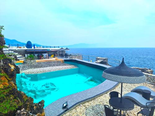 a swimming pool with the ocean in the background at Utopia Island Resort in Batangas City