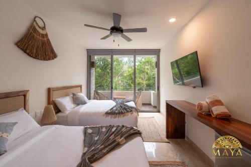 Un dormitorio con dos camas y un ventilador de techo. en NHOA 208C Lux 1BR Condo Jungle View in Aldea Zama, en Tulum
