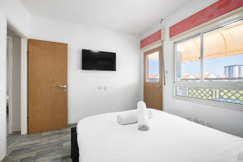 a bedroom with a white bed and a window at relaxing duplex in ashdod by torohome in Ashdod