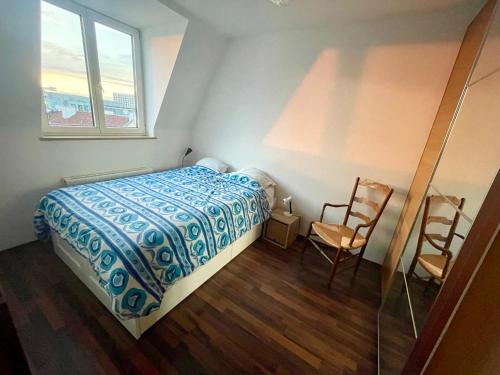 a bedroom with a bed and a chair and a window at Quiet room in big shared-flat 500m from Oktoberfest in Munich