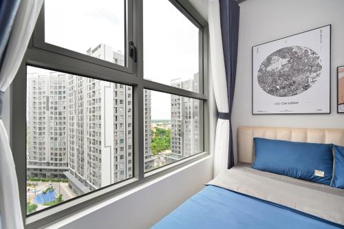 a bedroom with large windows and a blue bed at Căn hộ Westgate- 2N House in Ho Chi Minh City
