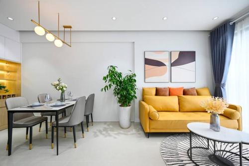a living room with a yellow couch and a table at Căn hộ Westgate- 2N House in Ho Chi Minh City