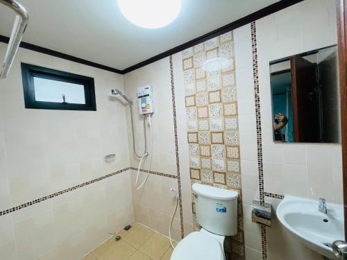 a bathroom with a shower and a toilet and a sink at The Monday ที่พักราคาถูก ใกล้หาดแหลมแม่พิมพ์ in Klaeng