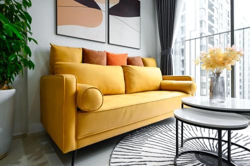 a yellow couch in a living room with a table at Căn hộ Westgate- 2N House in Ho Chi Minh City