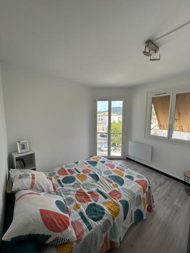 - une chambre avec un lit et une couette colorée dans l'établissement Saint Jo, à Quillan