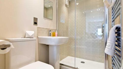 a bathroom with a toilet and a sink and a shower at The Telephone Exchange at Parsley Hay in Buxton