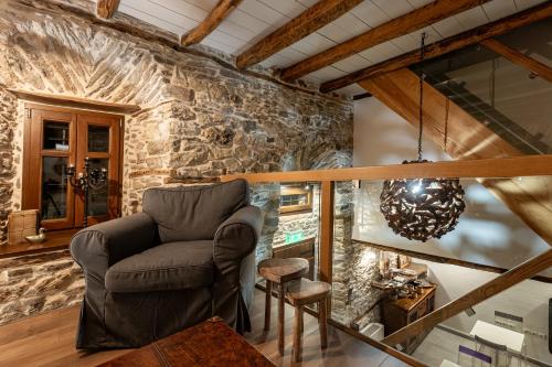 a living room with a chair and a stone wall at Mountain's Secret in Mouresi