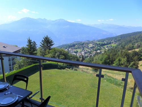 a balcony with a table and chairs and mountains at Apartment Clair-Azur B 65 by Interhome in Randogne