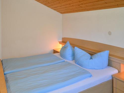 a bed with blue pillows in a room at Apartment Kassler - KPL602 by Interhome in Kappl