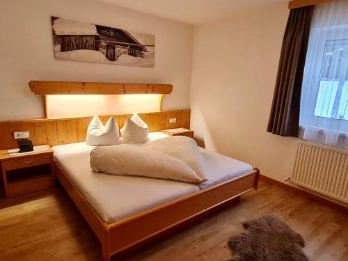 sypialnia z łóżkiem z białymi prześcieradłami i poduszkami w obiekcie Apartment Walch-2 by Interhome w mieście Fendels