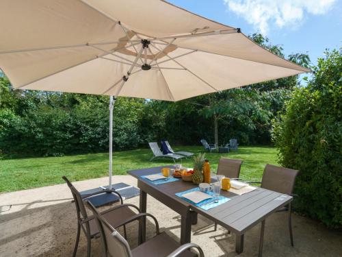 a wooden table with an umbrella and chairs at Holiday Home La Marinière Izella - SNR101 by Interhome in Sainte-Marine