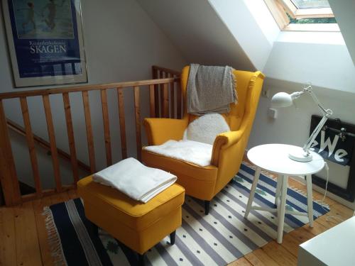 uma sala de estar com uma cadeira amarela e uma mesa em Holiday Home Kranich by Interhome em Troja
