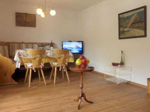 ein Wohnzimmer mit einem Tisch, Stühlen und einem TV in der Unterkunft Apartment Alba by Interhome in Zermatt