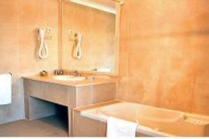 a bathroom with a sink and a tub and a mirror at Solar dos Caldeira e Bourbon in Zebras