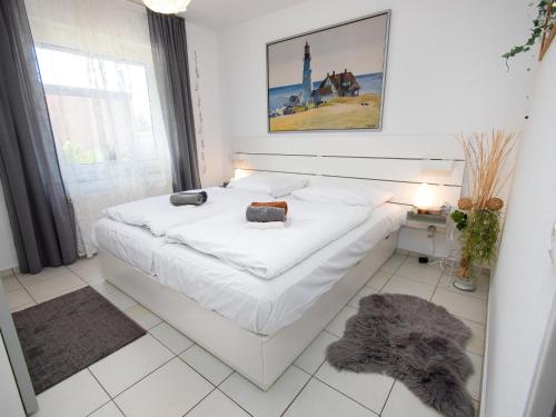 uma cama branca num quarto com uma janela em Apartment Muschelweg-2 by Interhome em Norddeich
