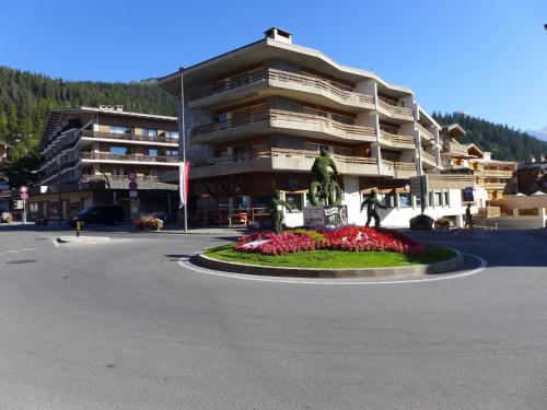 a building with a statue in the middle of a street at Apartment Rond-Point Apt- 17 by Interhome in Crans-Montana