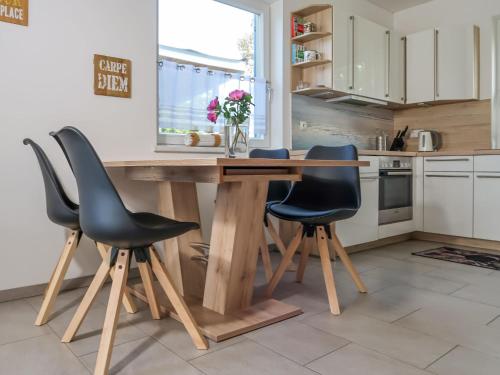 アルテフェーアにあるHoliday Home Achterblick 2 by Interhomeのキッチン(木製テーブル、黒い椅子2脚付)