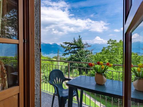 uitzicht vanaf het balkon van een huis met een tafel en stoelen bij Holiday Home Bragna by Interhome in Pianello Del Lario