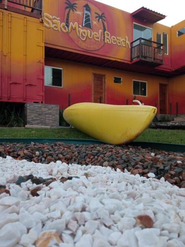 a yellow boat sitting on top of a pile of rocks at Pousada São Miguel Beach Beira Mar in Penha