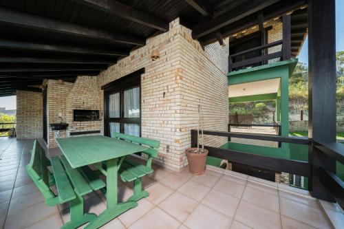a green table and chairs on a patio at Pousada Albacora in Bombinhas