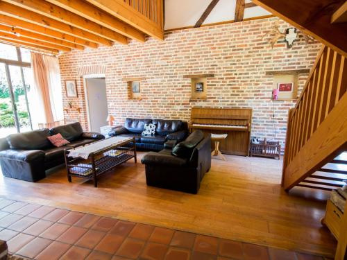 La Chapelle-Saint-Sauveur的住宿－Holiday Home Alexandre - BCA300 by Interhome，客厅配有皮革家具和砖墙